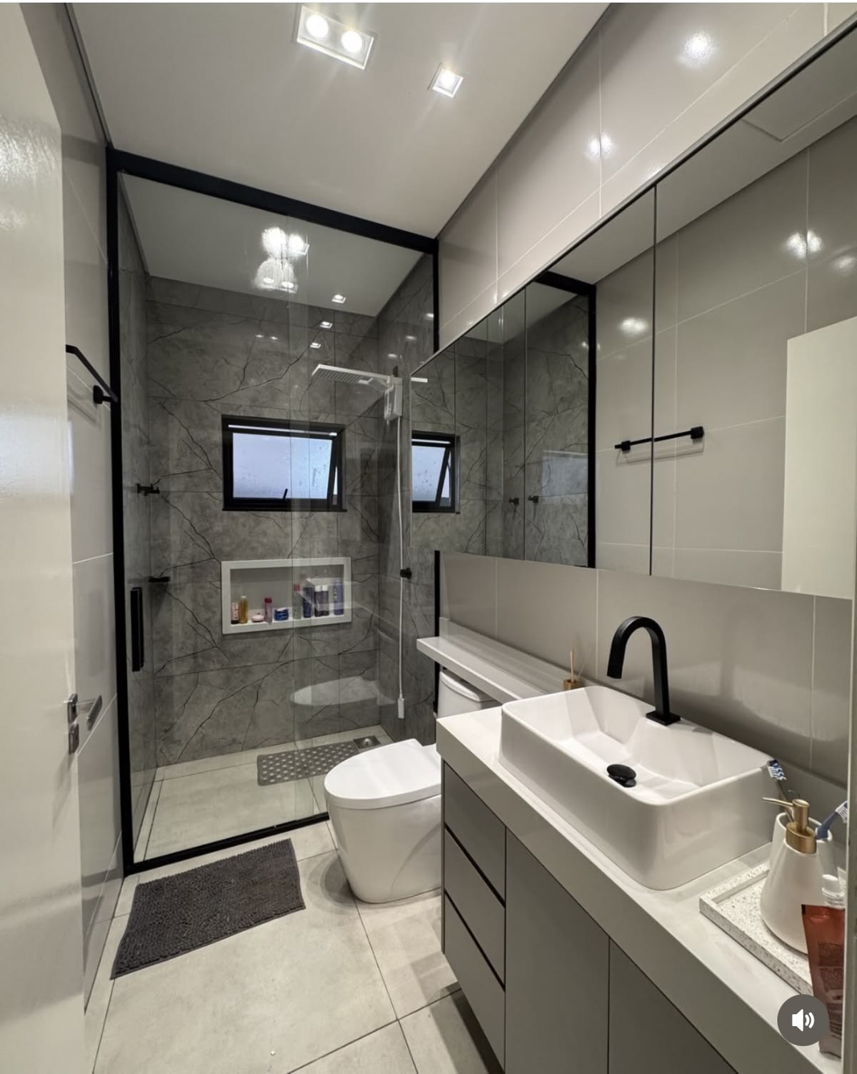 Completed bathroom renovation with large-format tile and a frameless glass shower